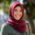 Portrait of young muslim woman wearing hijab head scarf in city while looking at camera. Closeup face of cheerful woman covered with headscarf smiling outdoor. Casual islamic girl at park.